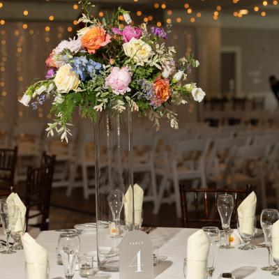 Elegant table setting with a tall floral centerpiece and a table number 4.