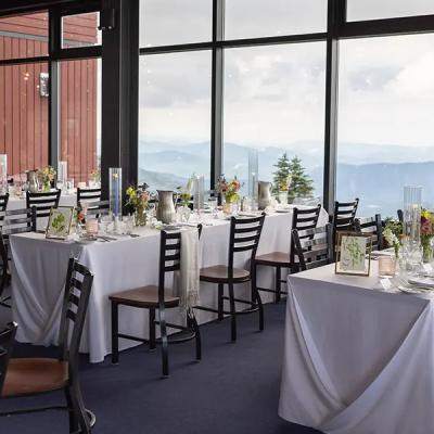 Elegant dining room with tables set against mountain views and large windows.
