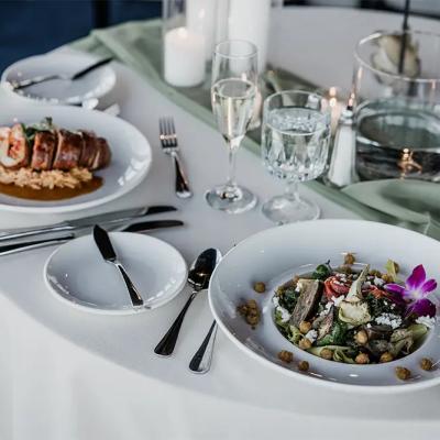 Elegant dining table with a gourmet meal, glasses of water, and candles.