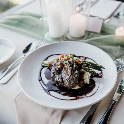 A gourmet plate featuring beef, asparagus, and mashed potatoes, elegantly served on a table.