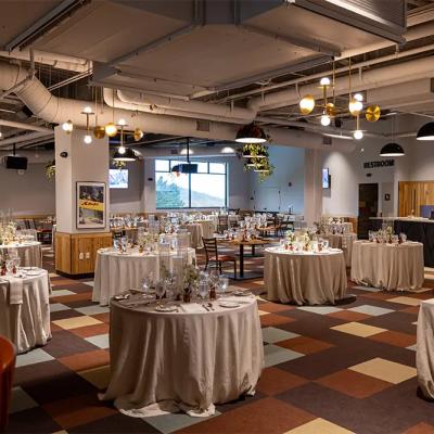 Elegant dining area with round tables, neatly set, dim lighting, and modern decor.