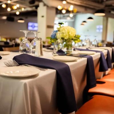 Elegant dining setting with white and navy table linens, plates, and floral centerpieces.