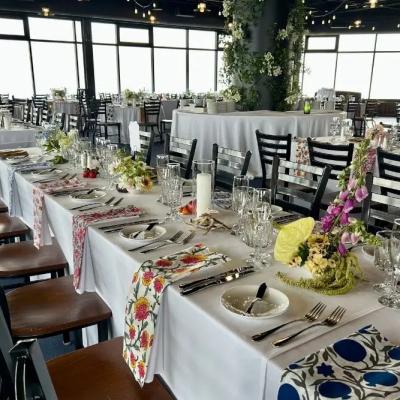 Elegant dining setup with floral decor and tables set for an event.