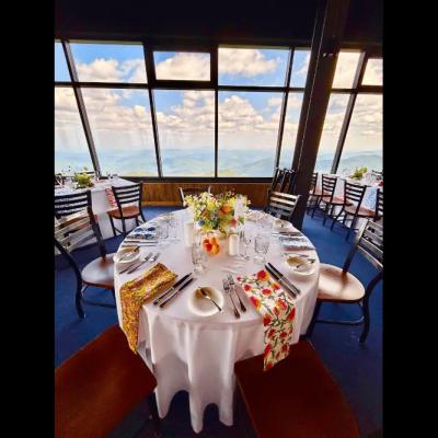 Table set for dining with flower centerpiece and panoramic mountain views in the background.