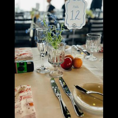 Table setting with flowers, fruit, glassware, and a sign indicating 