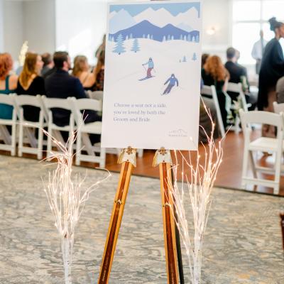 Wedding seating sign with skiing theme, promoting love for both bride and groom.