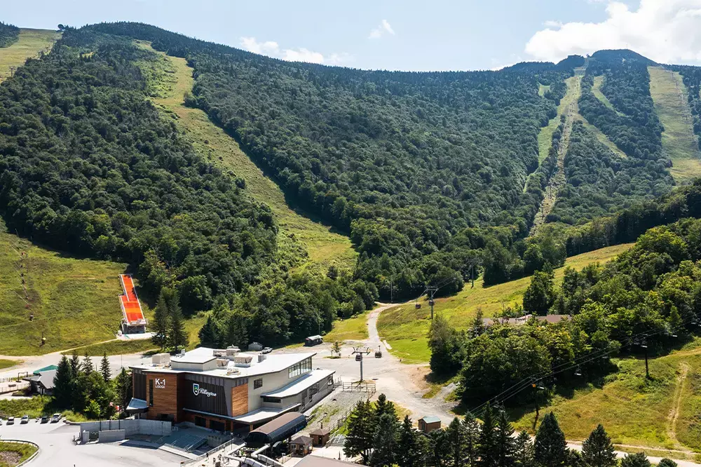 A scenic view of a mountain resort with ski slopes and lush greenery.