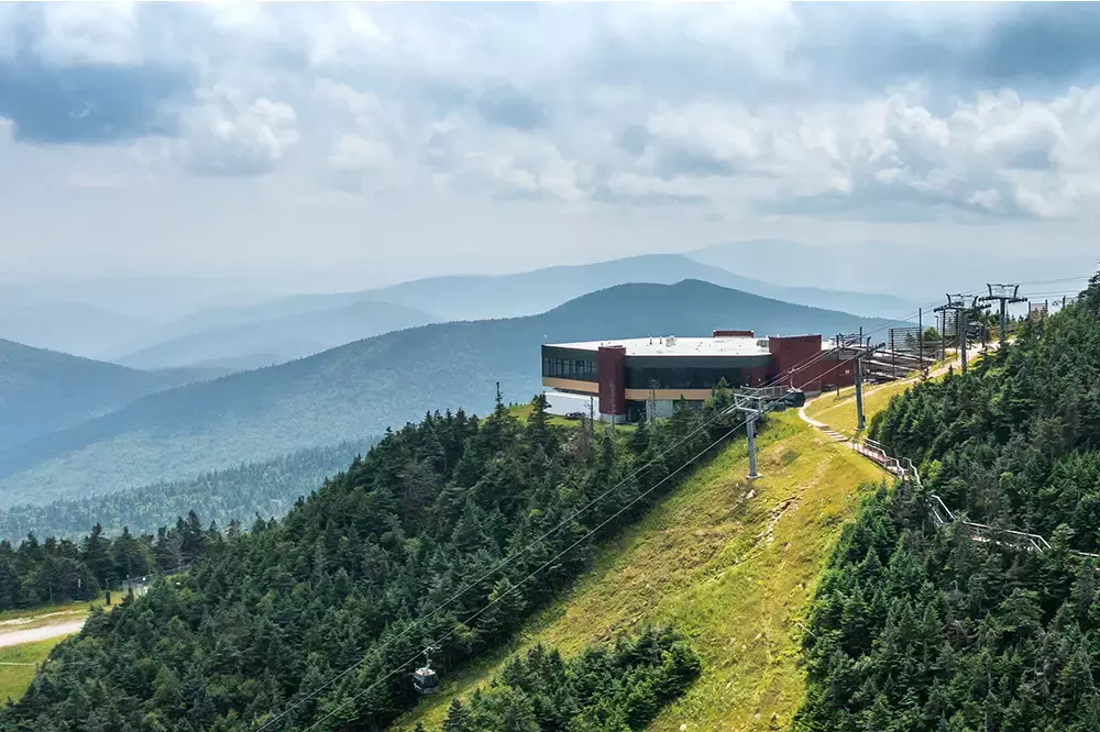 Mountain view featuring a ski resort with a chairlift and surrounding trees.