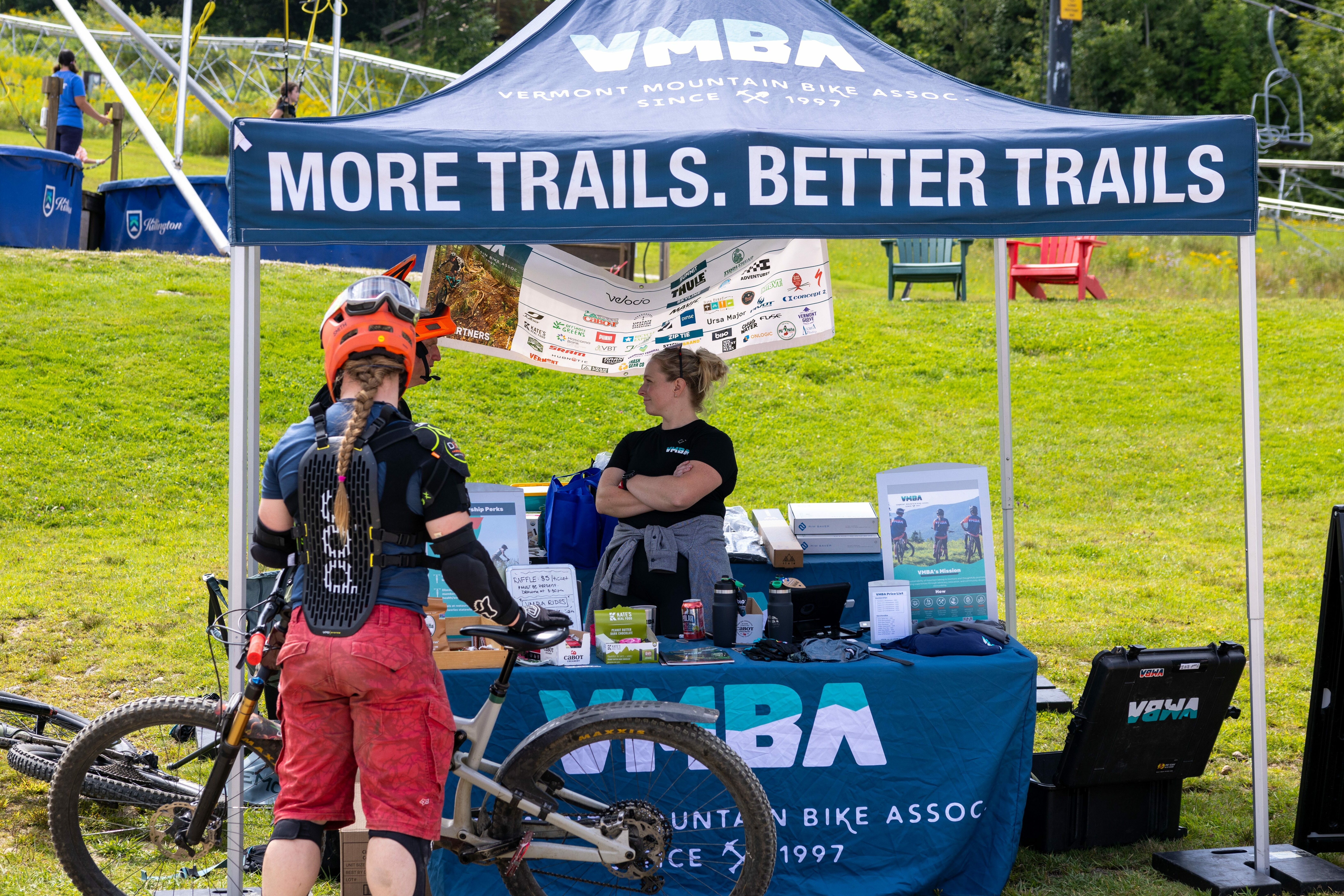 A cyclist at the VMBA booth discussing mountain biking trails.