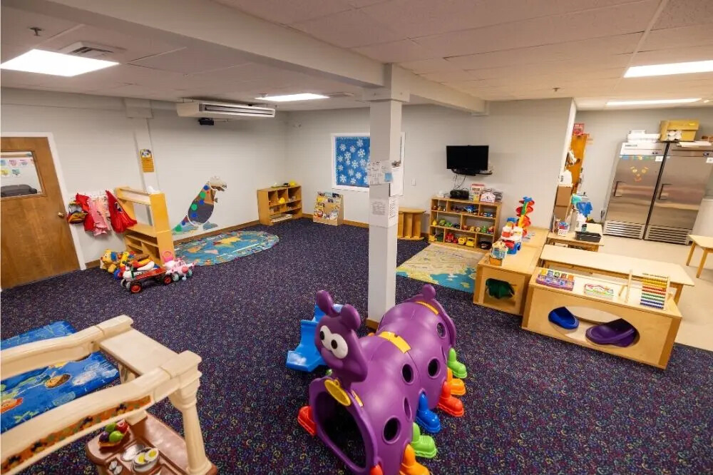 Bright, colorful children's playroom with toys, play structures, and learning areas.