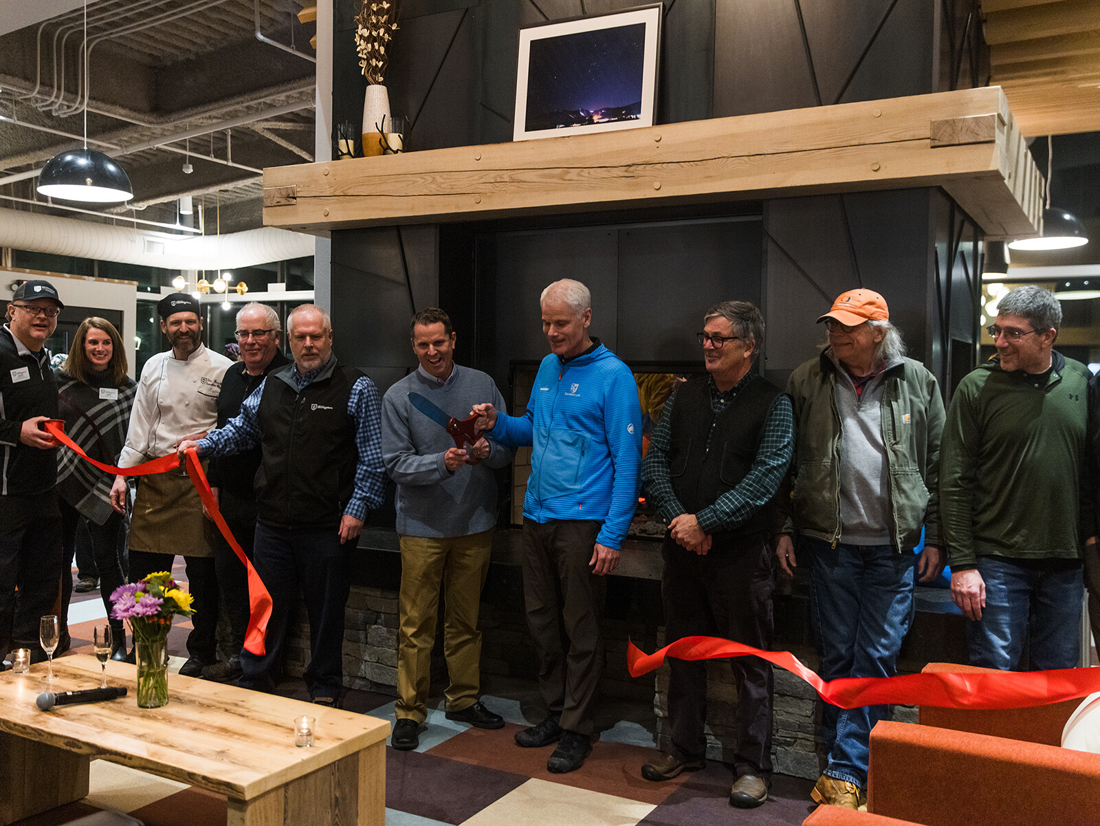 Group of people at a ribbon-cutting event in a modern indoor space.