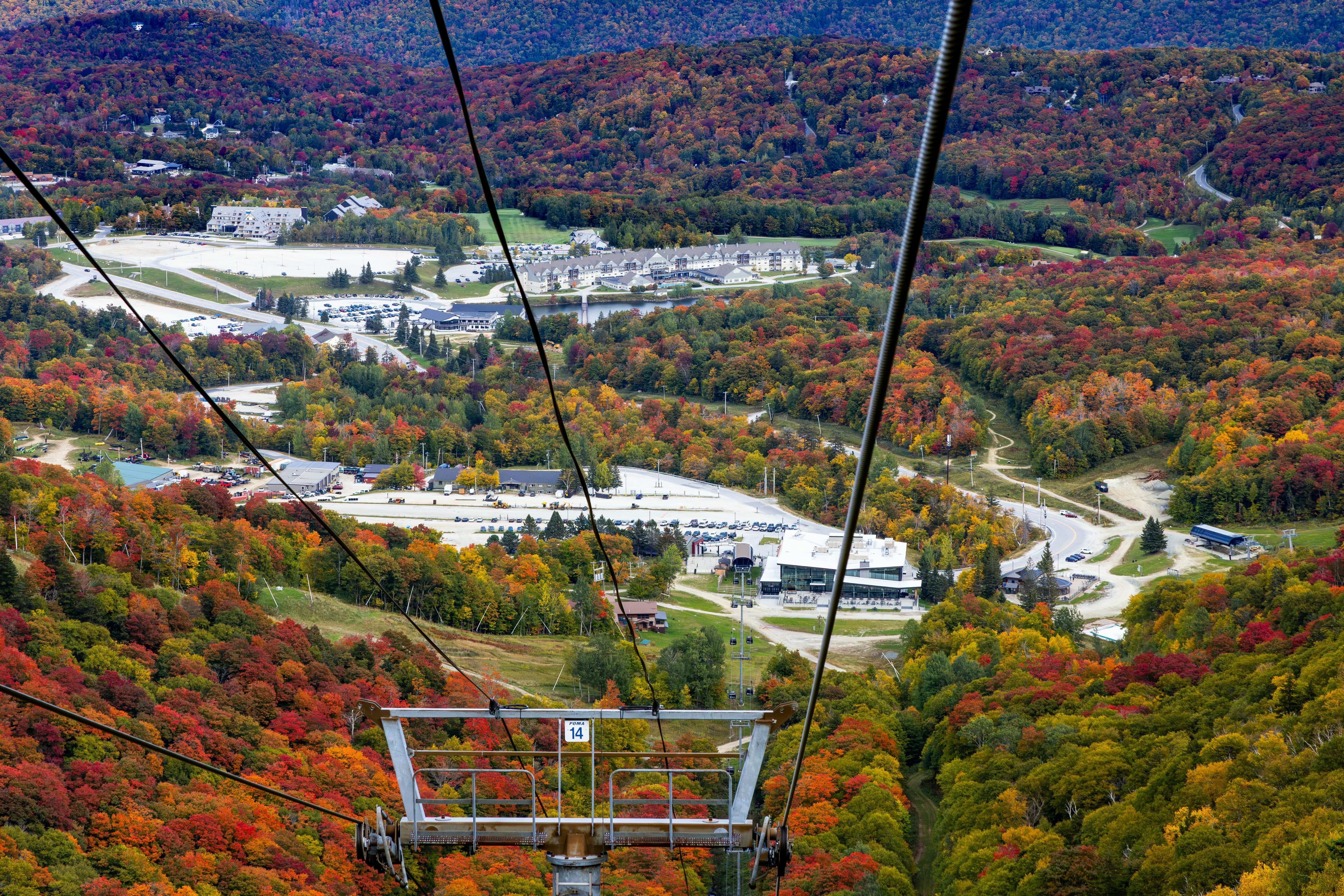 Aerial view from a cable car, showcasing vibrant autumn foliage and parks below.