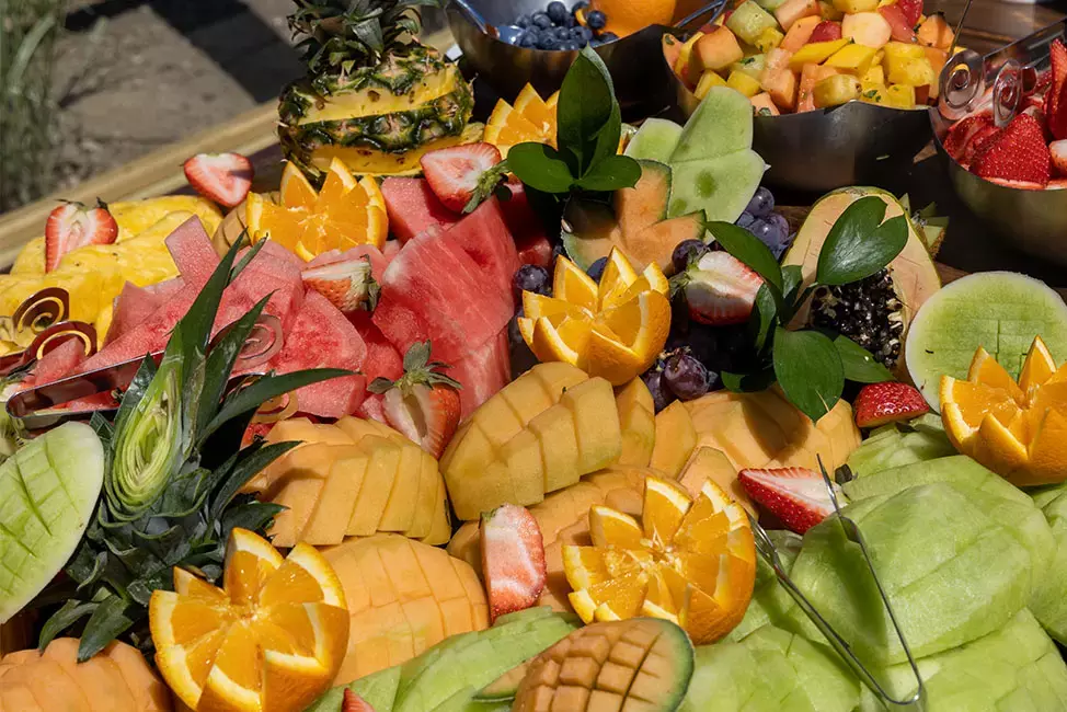 A vibrant assortment of sliced fruits, including melons, oranges, and strawberries.