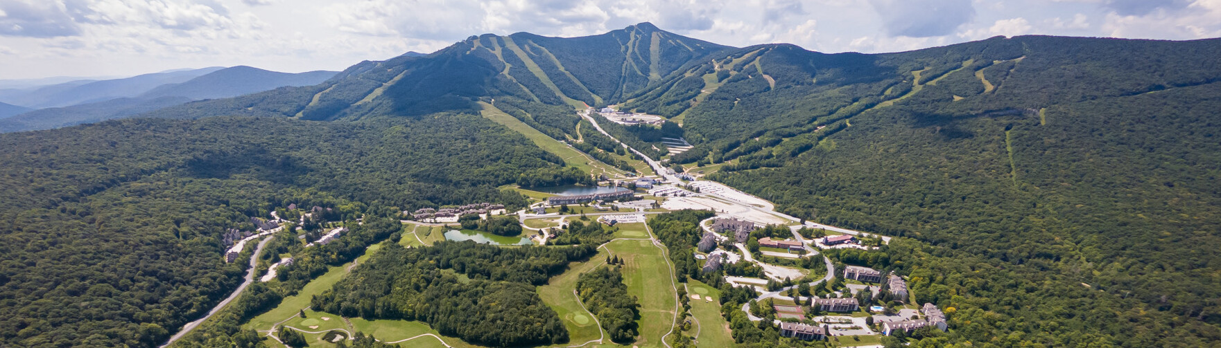 A panoramic view of a mountainous landscape with ski slopes and resort buildings.