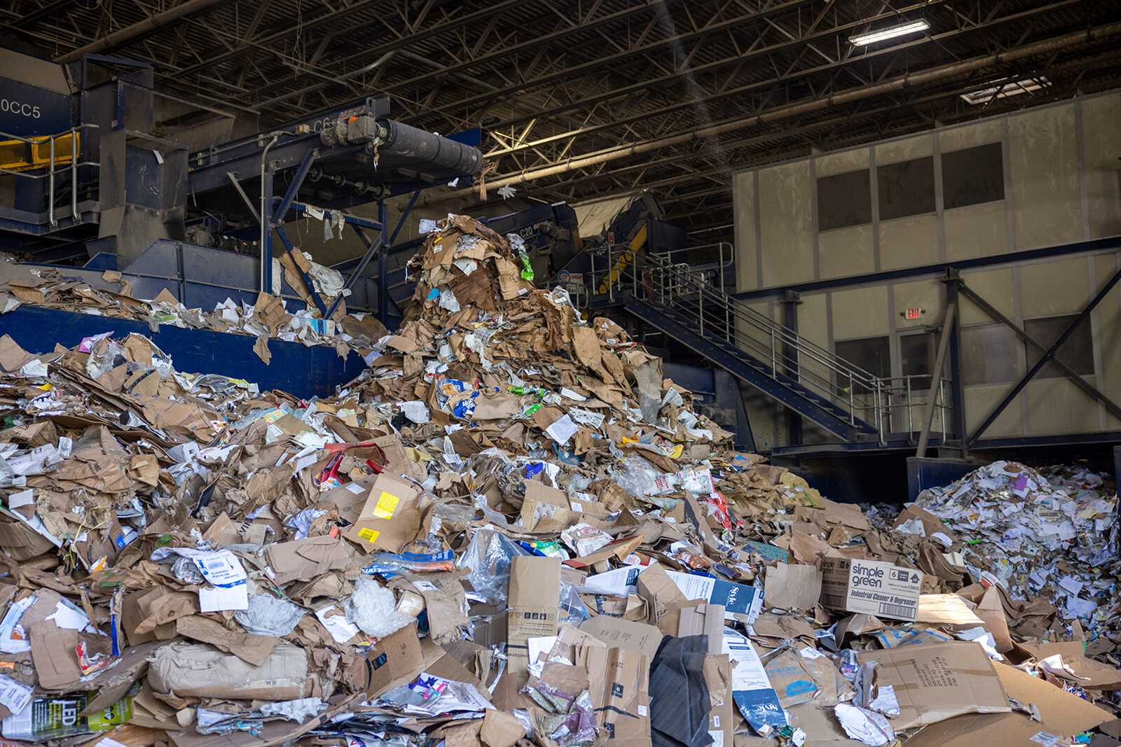 A large pile of cardboard and paper waste in a recycling facility.