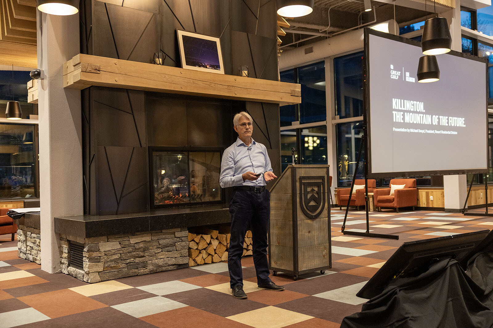 A speaker presents on "Killington: The Mountain of the Future" in a cozy venue.
