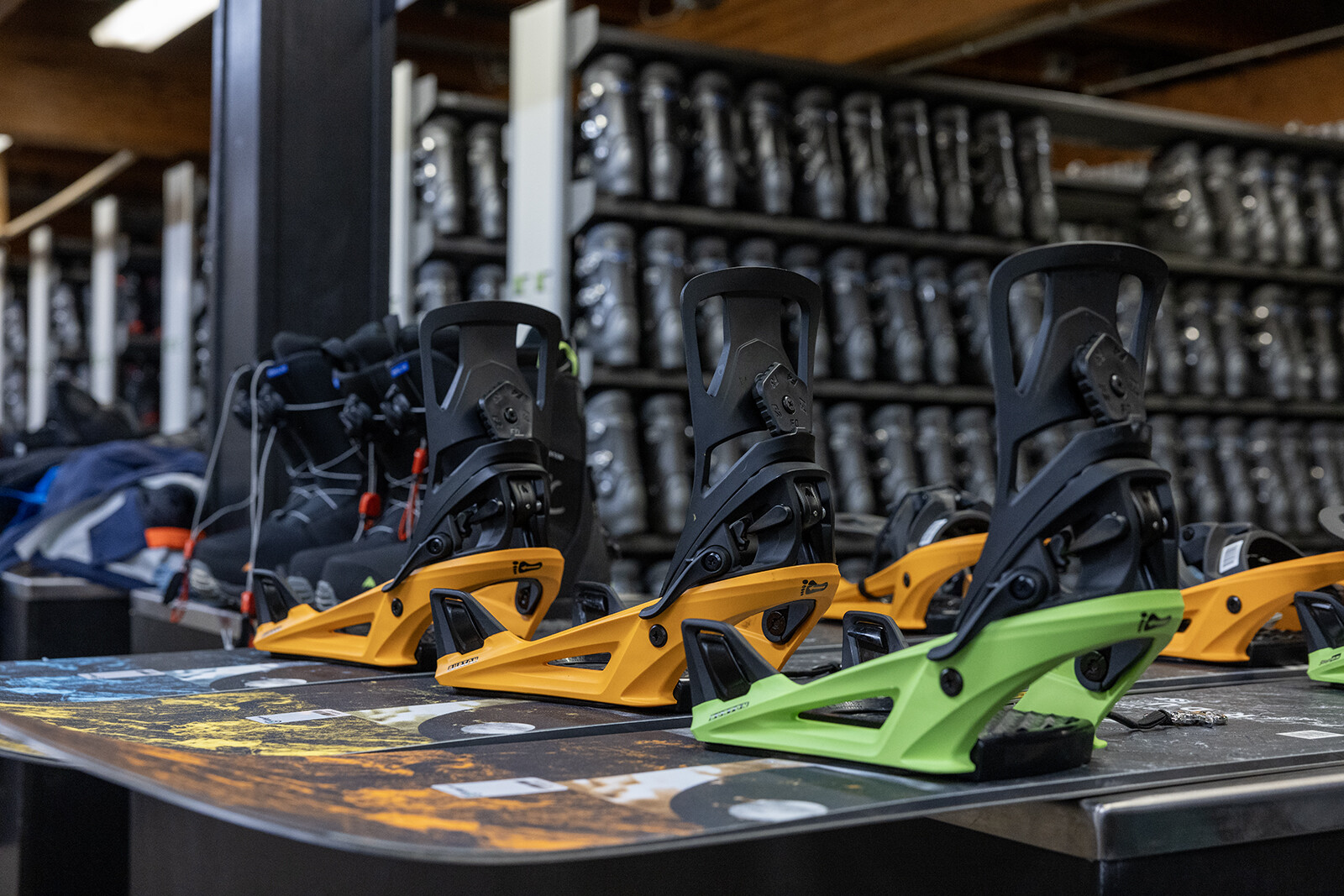 Ski equipment display featuring orange and green bindings on a snowboard.