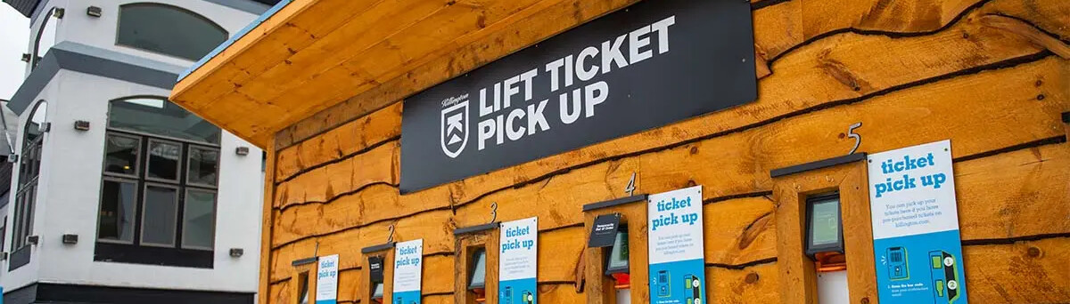 Lift ticket pickup booth with signage and ticket windows in a wooden structure.