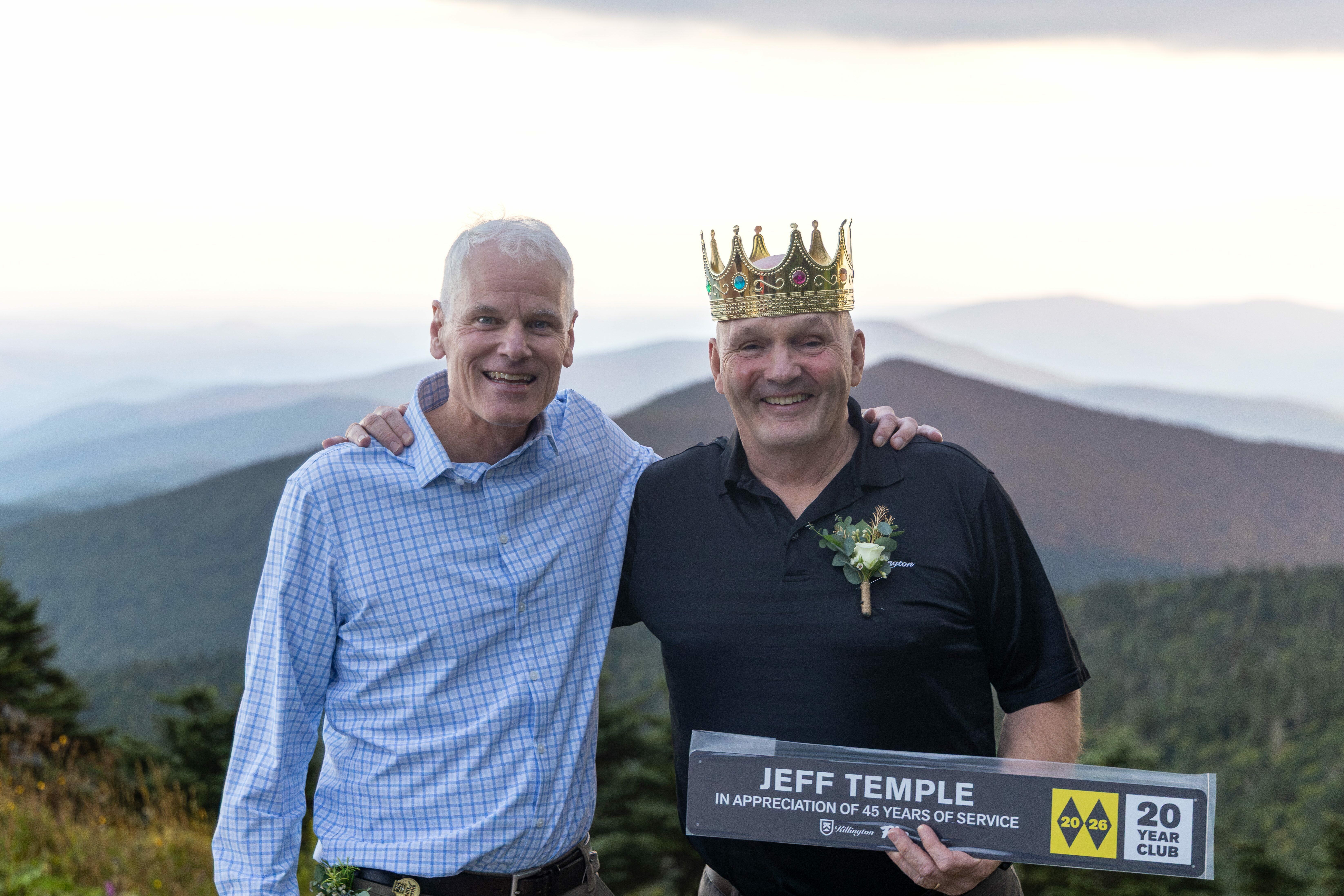 Two men celebrate with a sign for Jeff Temple's 45 years of service and a crown.