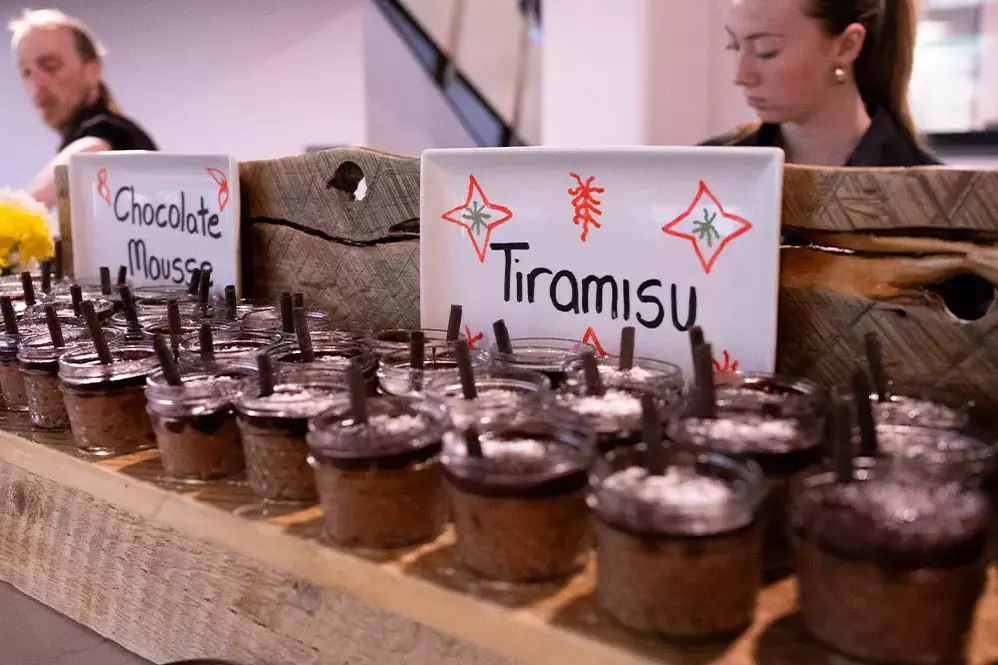 A dessert display featuring chocolate mousse and tiramisu in jars.