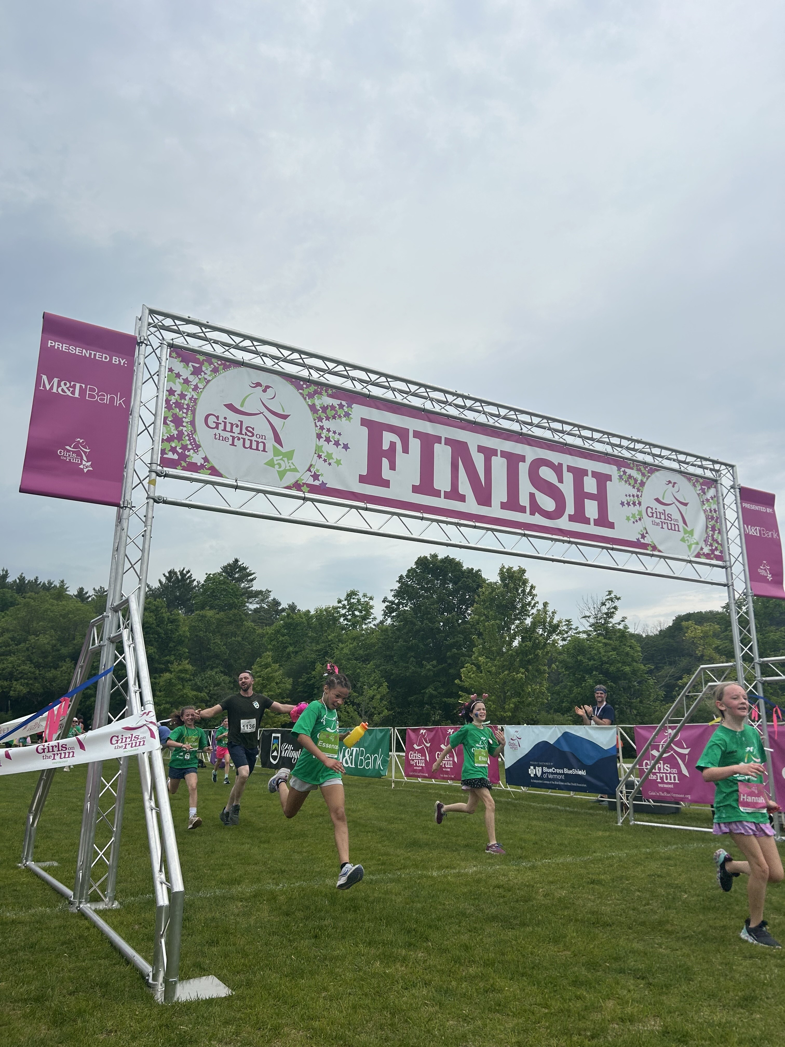 Children and parents cross the finish line at Girls on the Run 5k