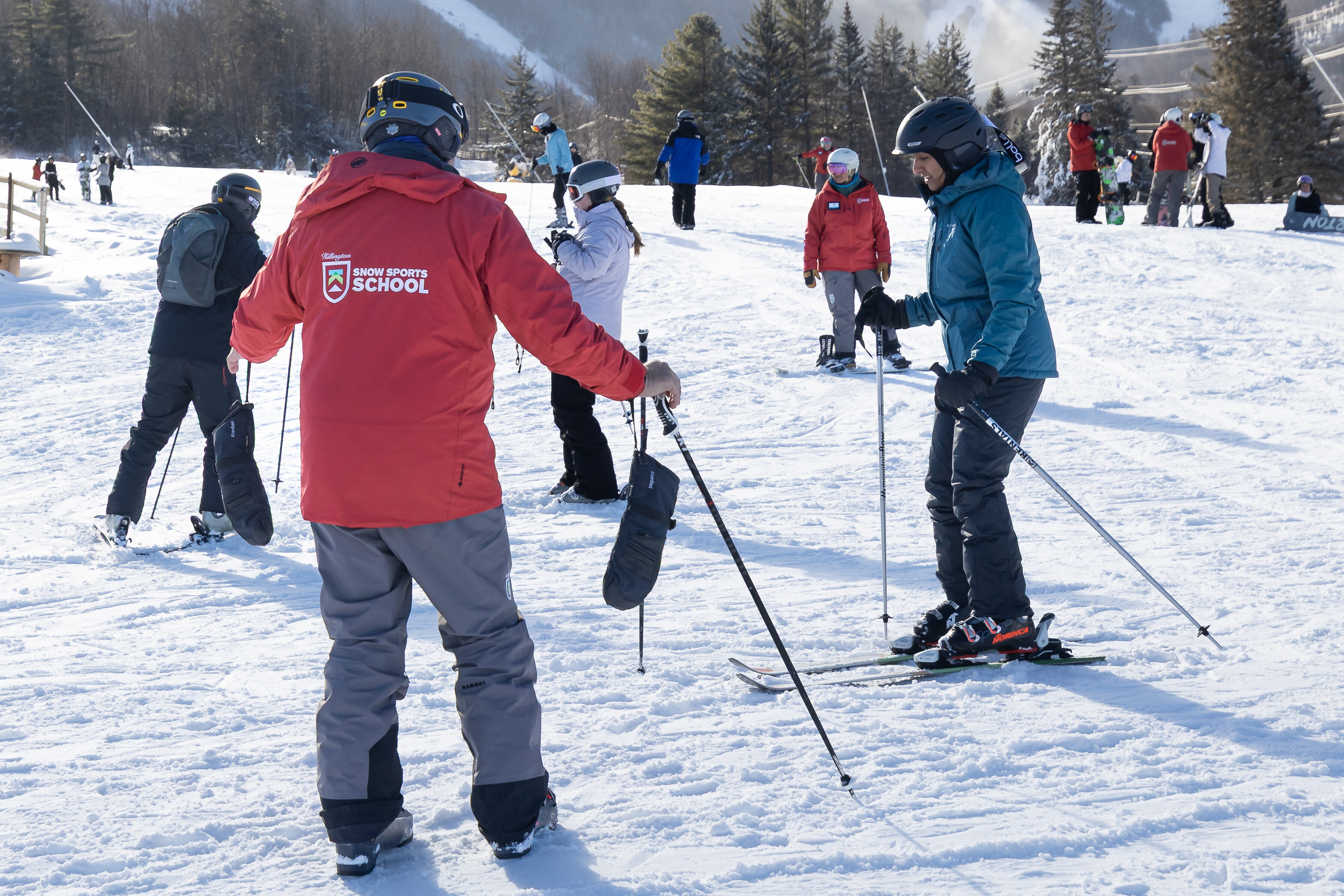 Skiers receive instruction on a snowy slope at a ski school.