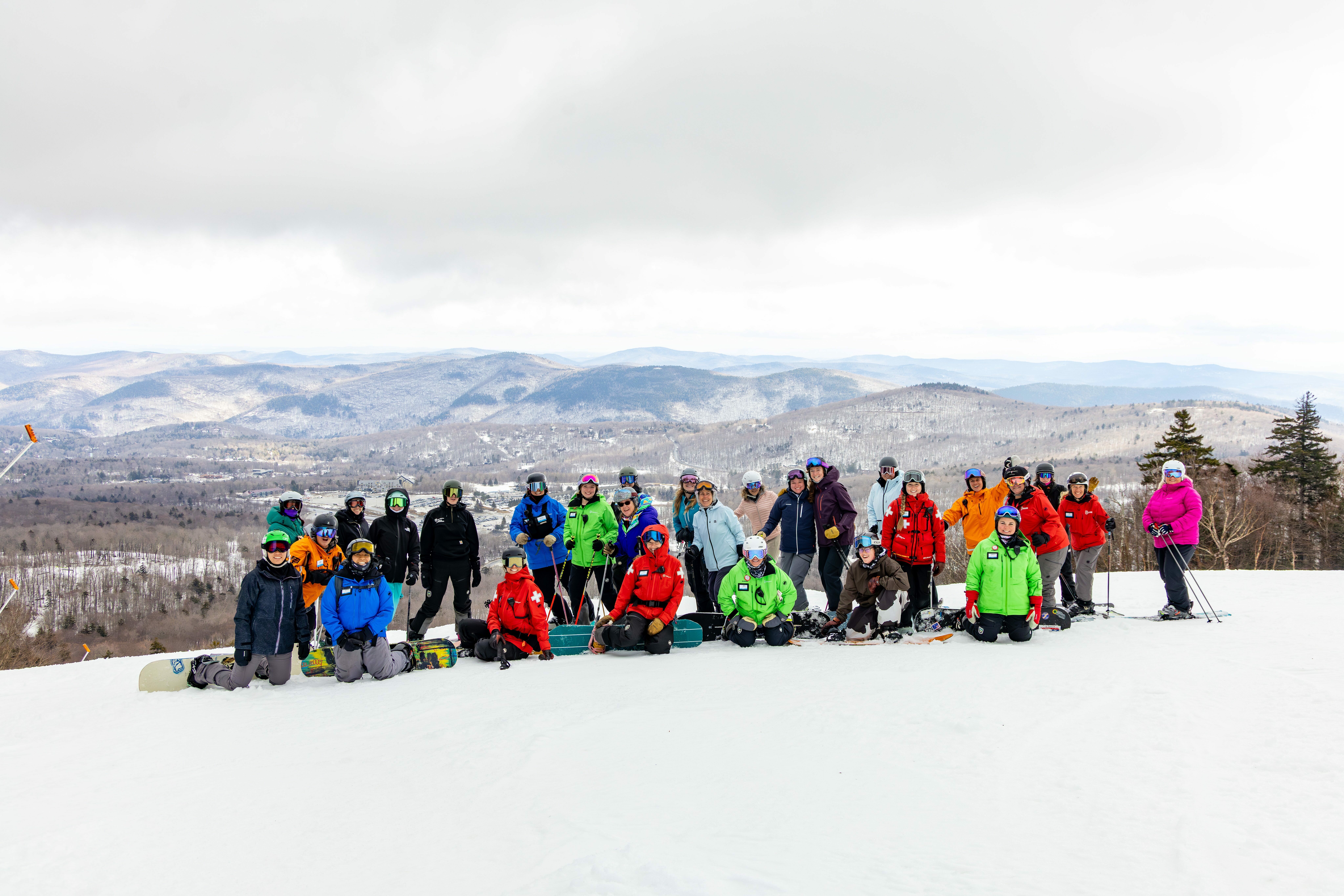 A group of women pose for a photo on a ski trail at Killington Resort