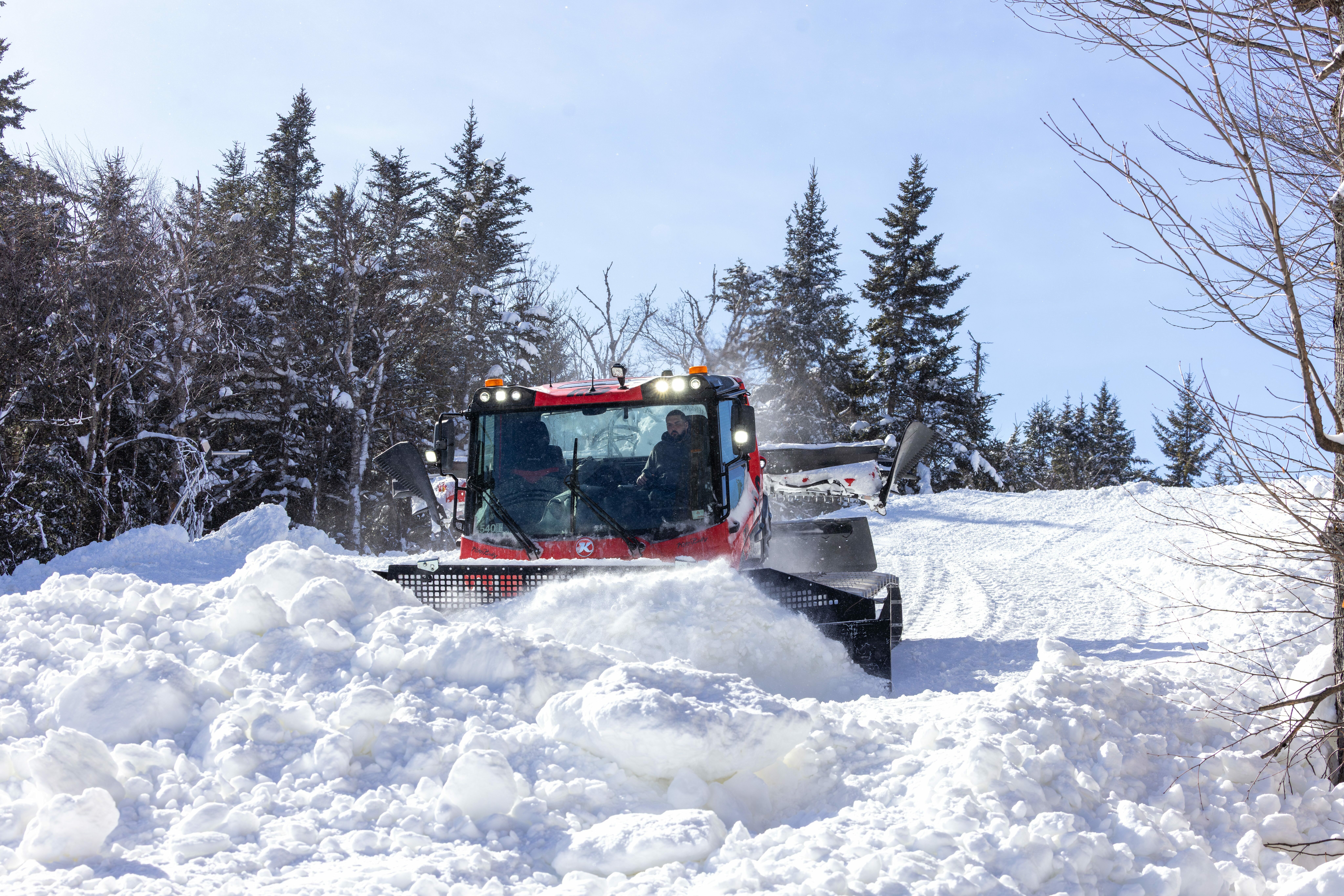 Grooming tractor operator pushing snow during the winter