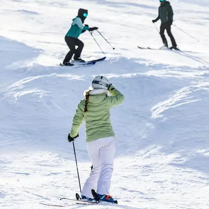 Skiers navigating a snowy slope on Killington Mountain.