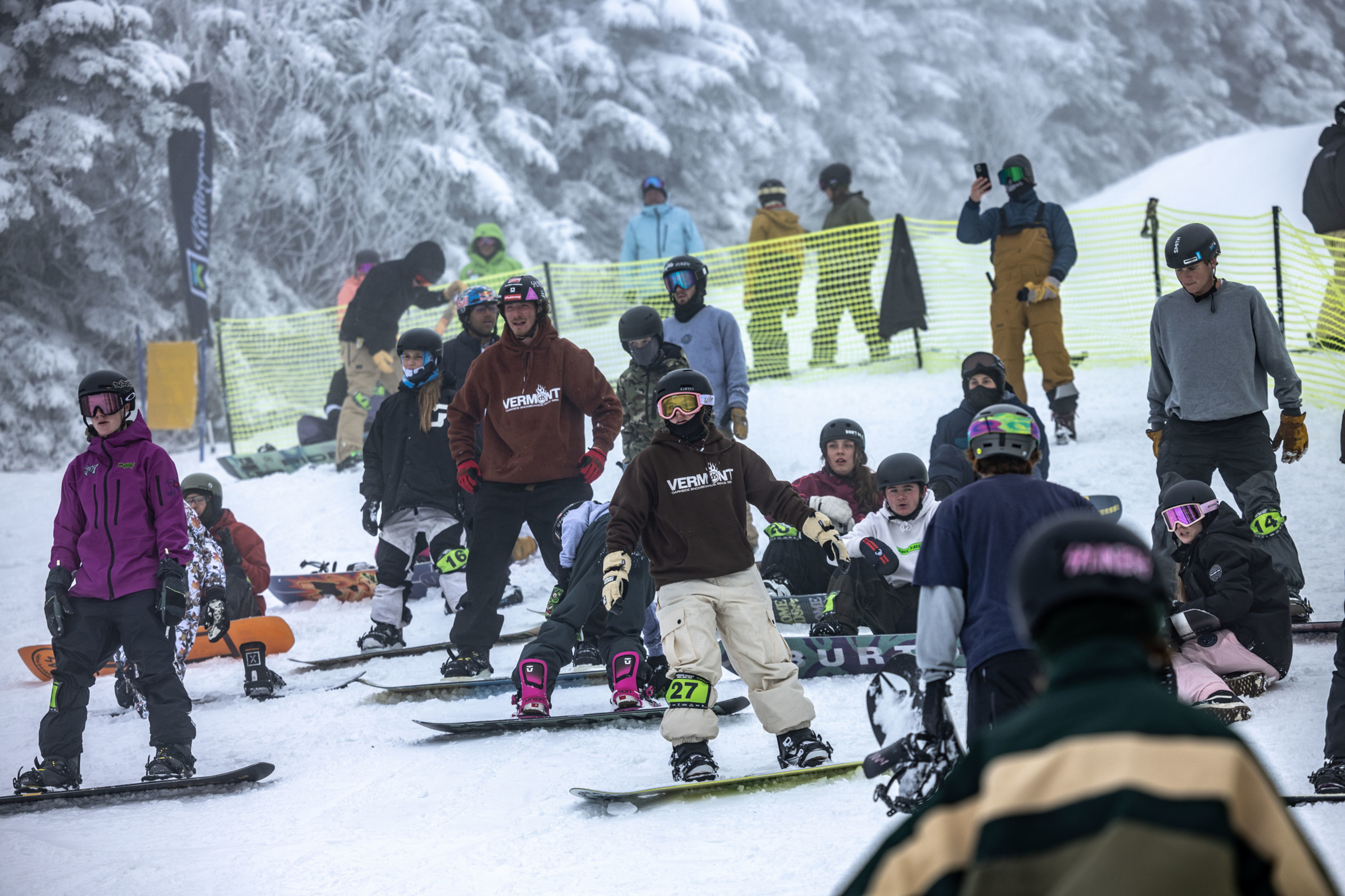 A group of snowboarders on a snowy slope, preparing for a fun event or competition.
