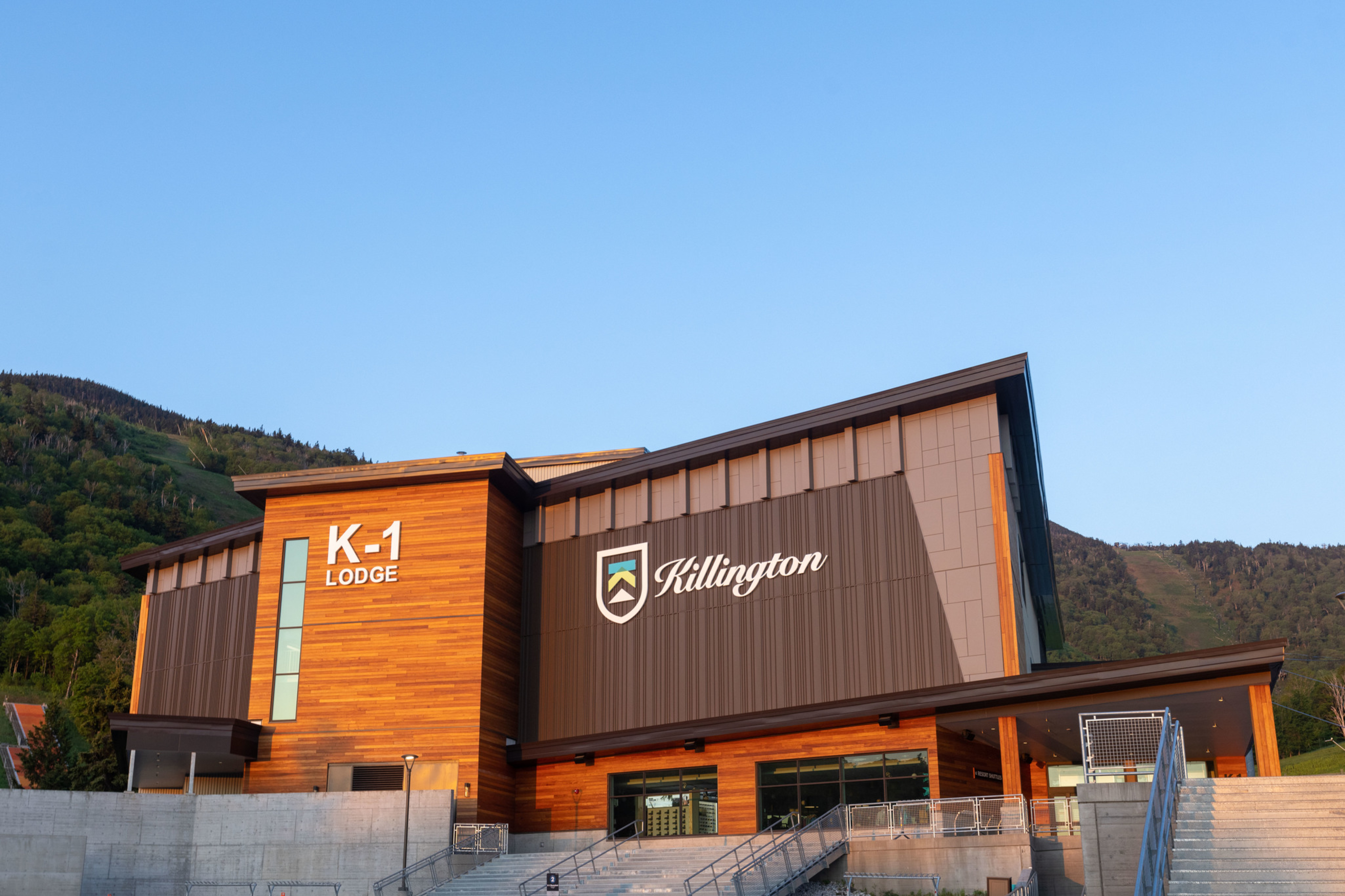 K-1 Lodge building in Killington, with mountains in the background and clear blue sky.