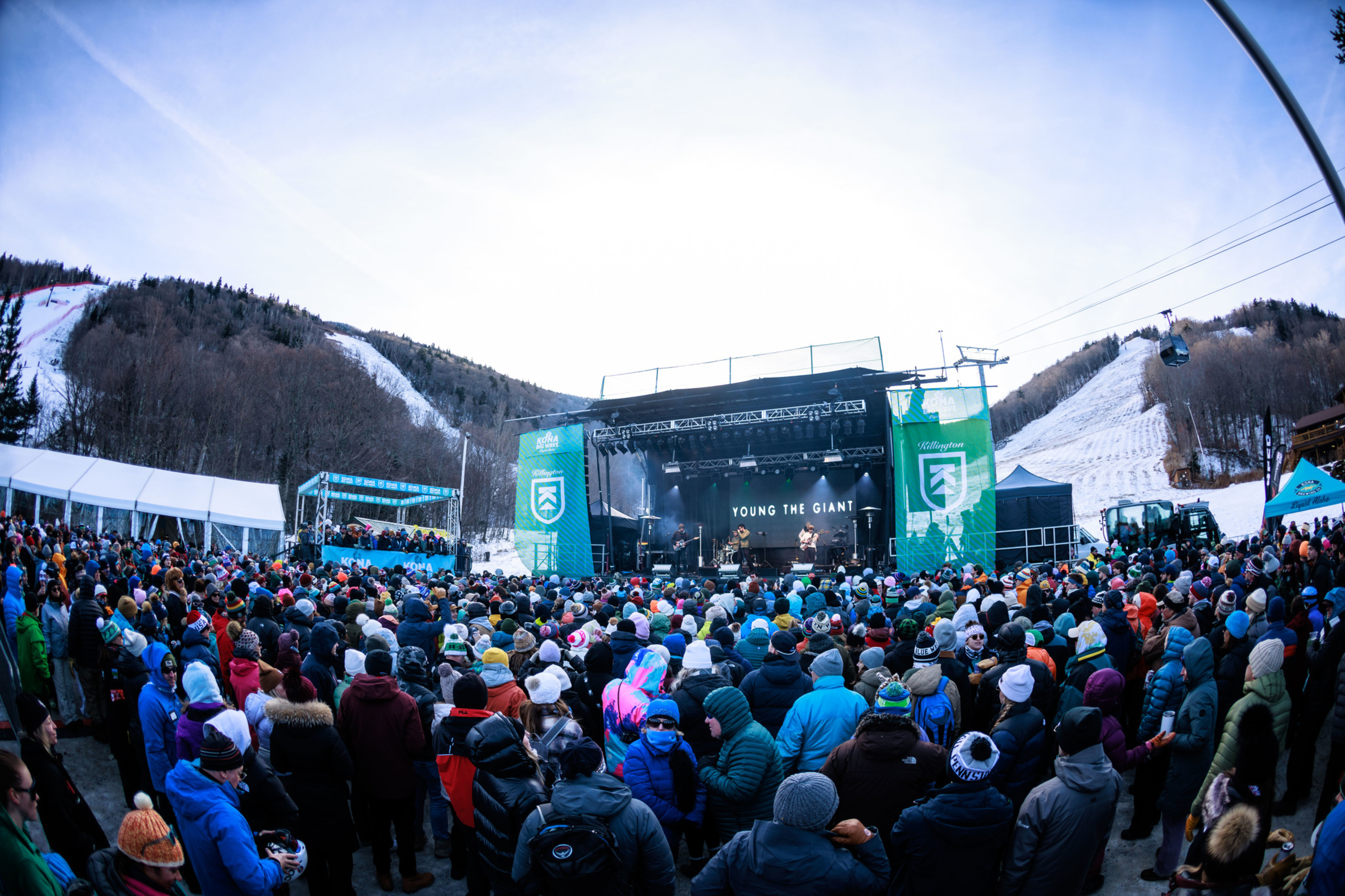 Crowd at a music festival featuring "Young the Giant" on a snowy mountain slope.