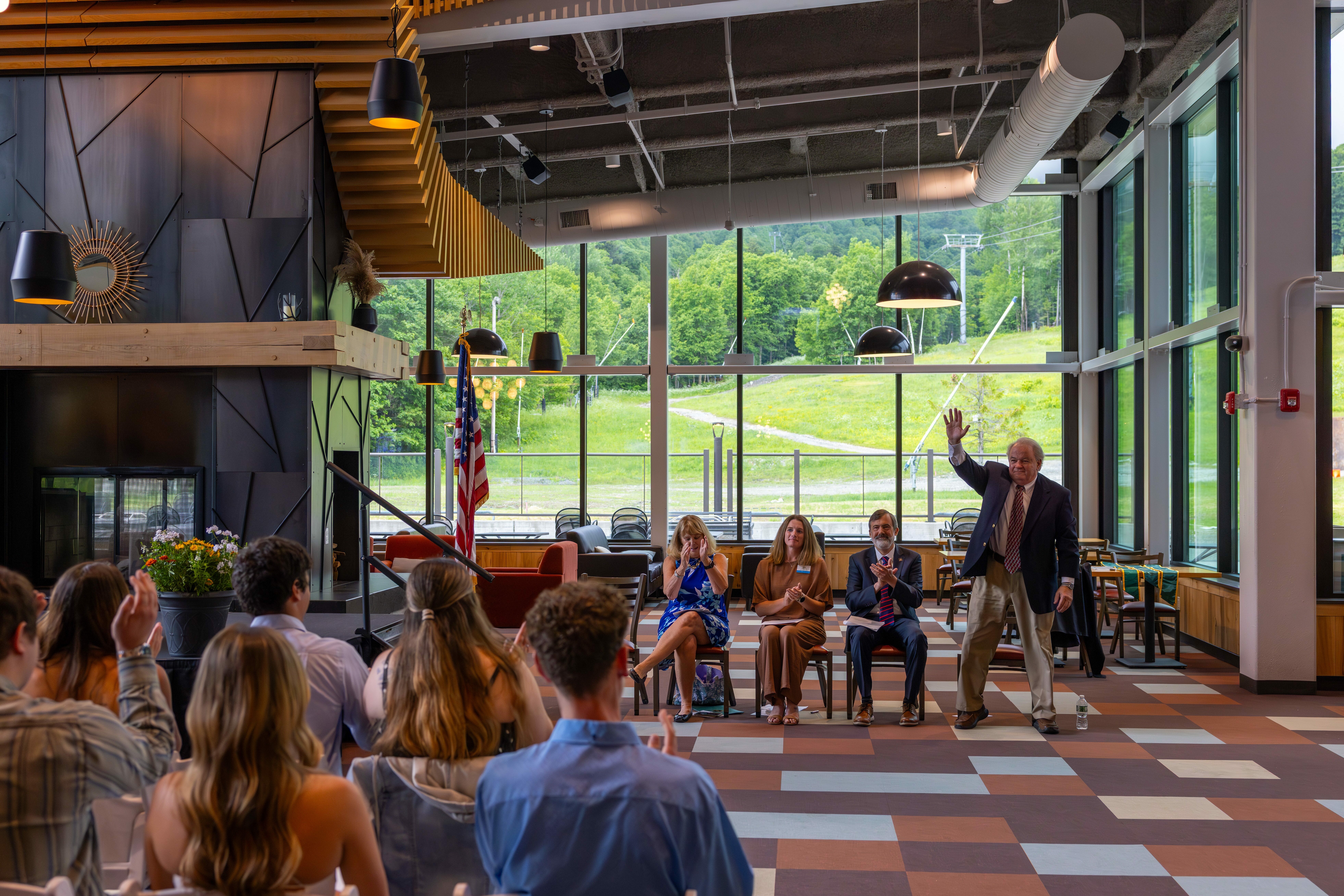 Frank Pauze stands up to acknowledge applause during 2026 RHM graduation ceremony