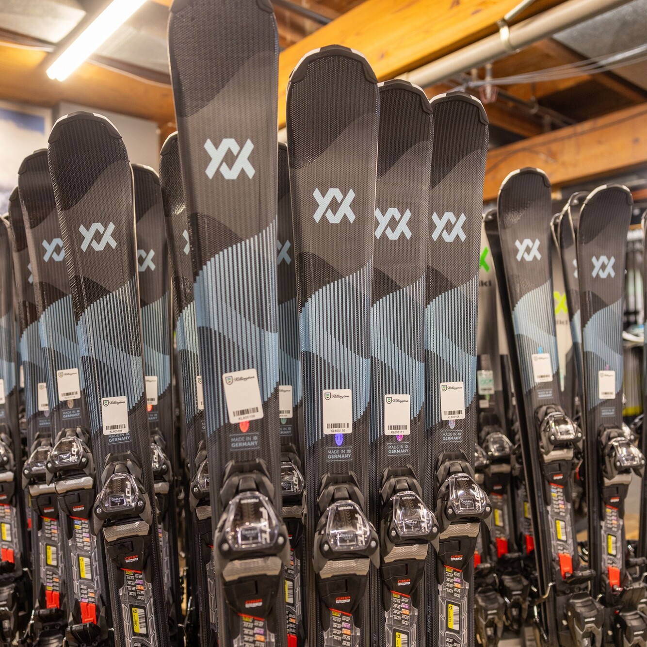 A display of multiple pairs of skis with bindings in a retail setting.