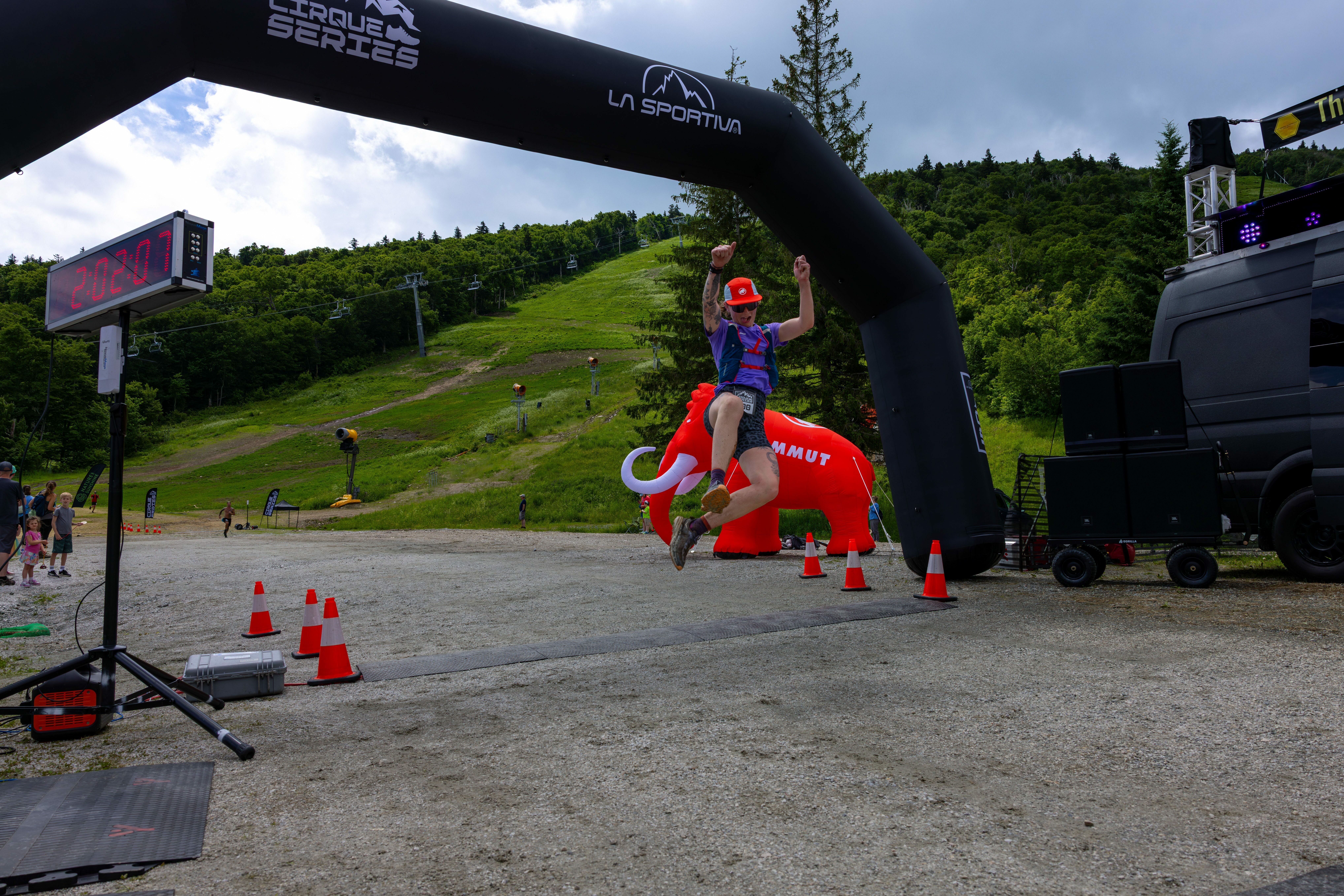 Runner joyfully leaping through the finish line at Cirque Series