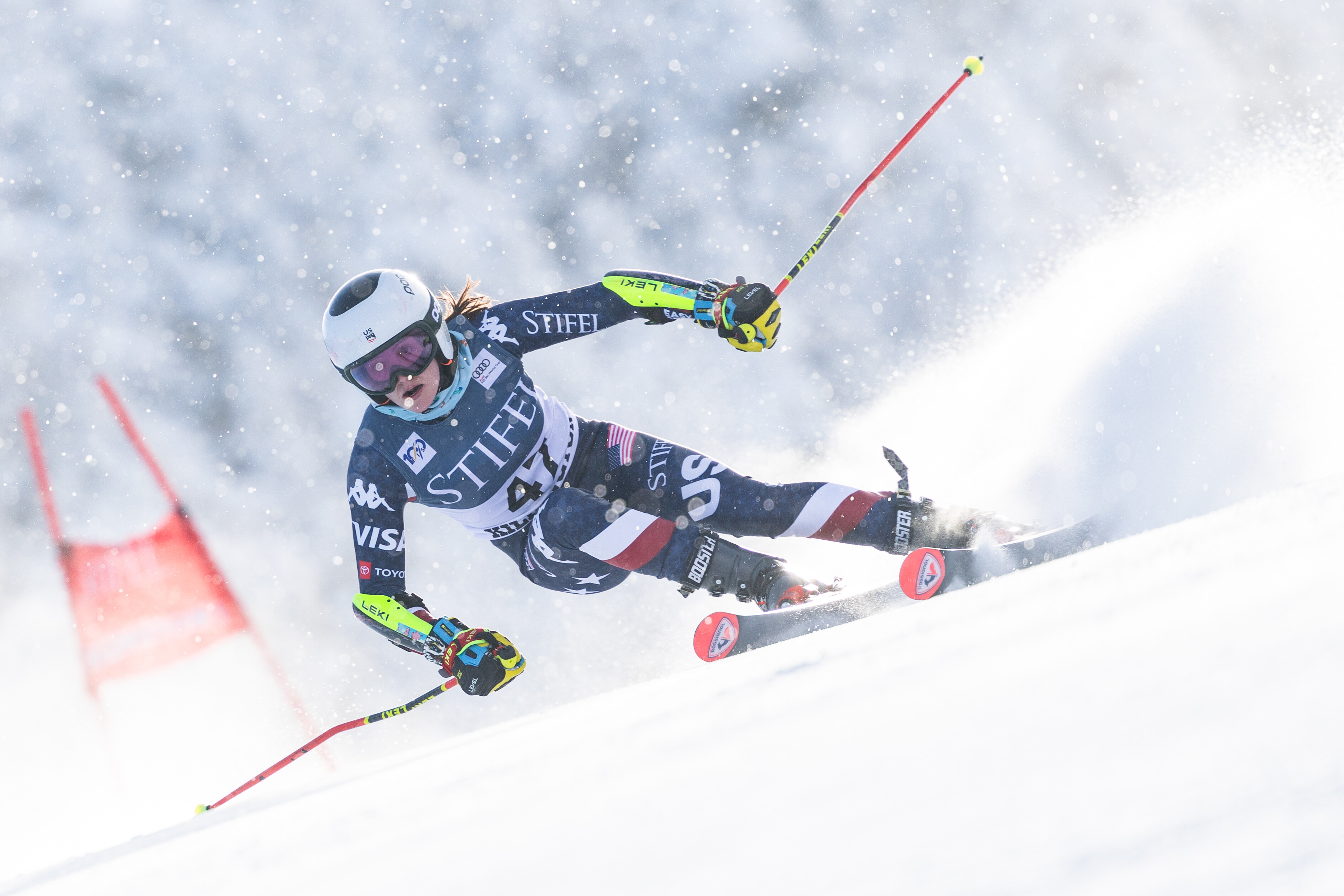 A skier competes in a slalom race, navigating through snowy terrain.