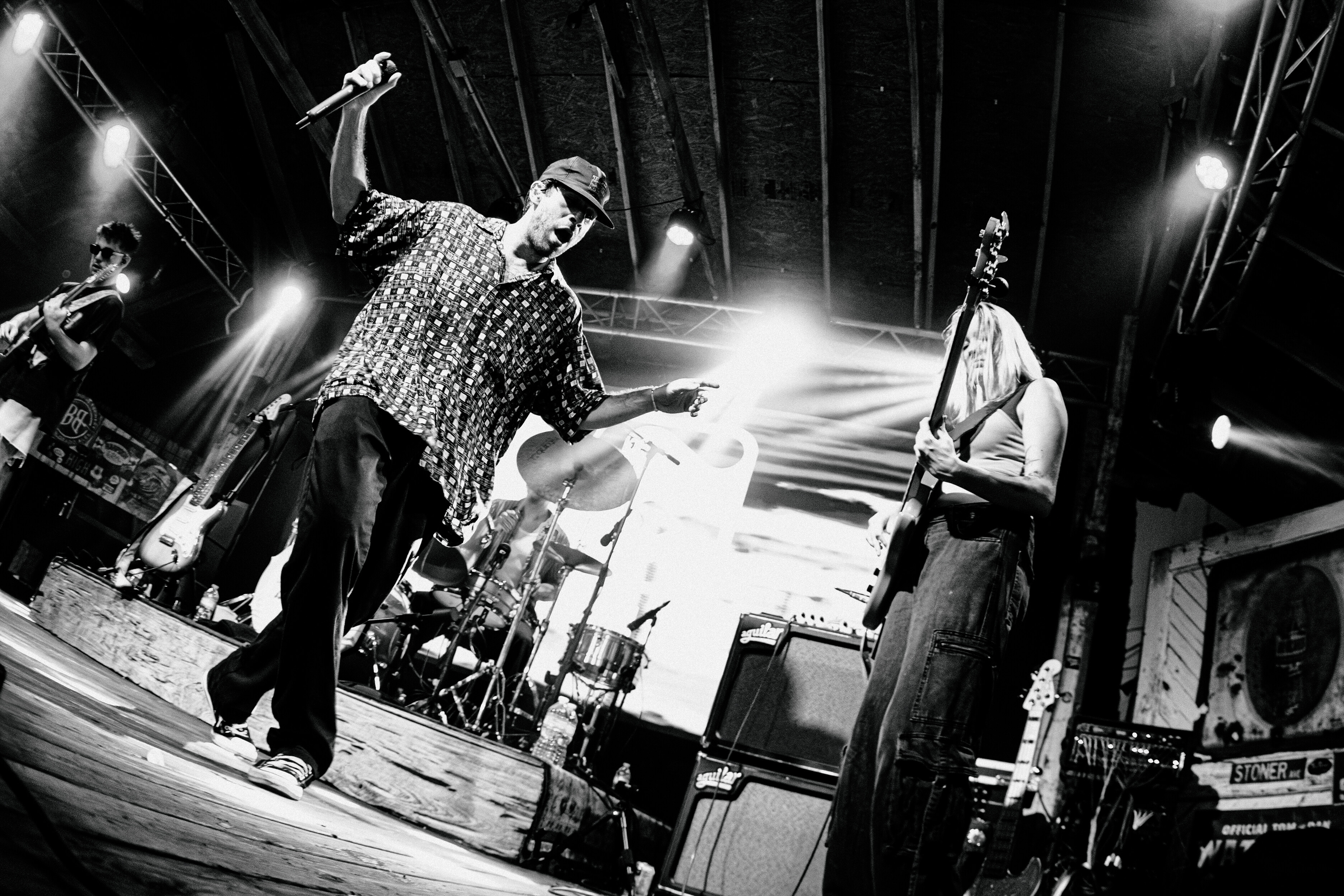 Musicians performing live on stage, captured in dynamic black and white.