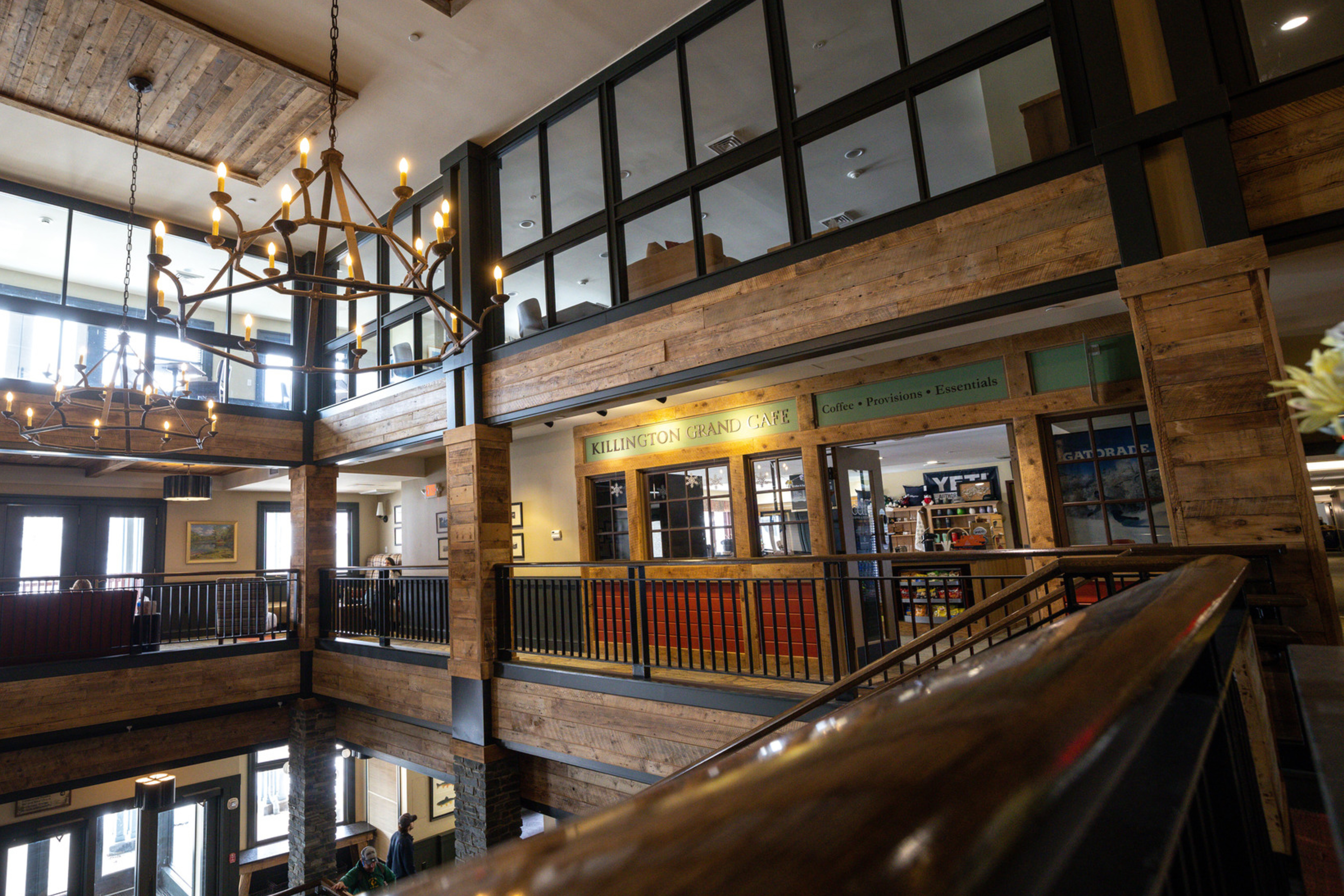Interior of a rustic caf&eacute; featuring wooden beams, a chandelier, and a caf&eacute; sign.