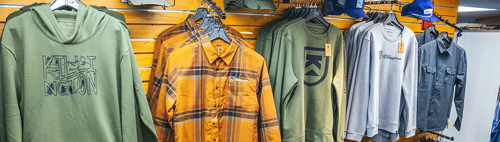 Hanging display of hoodies and shirts in various colors and styles.