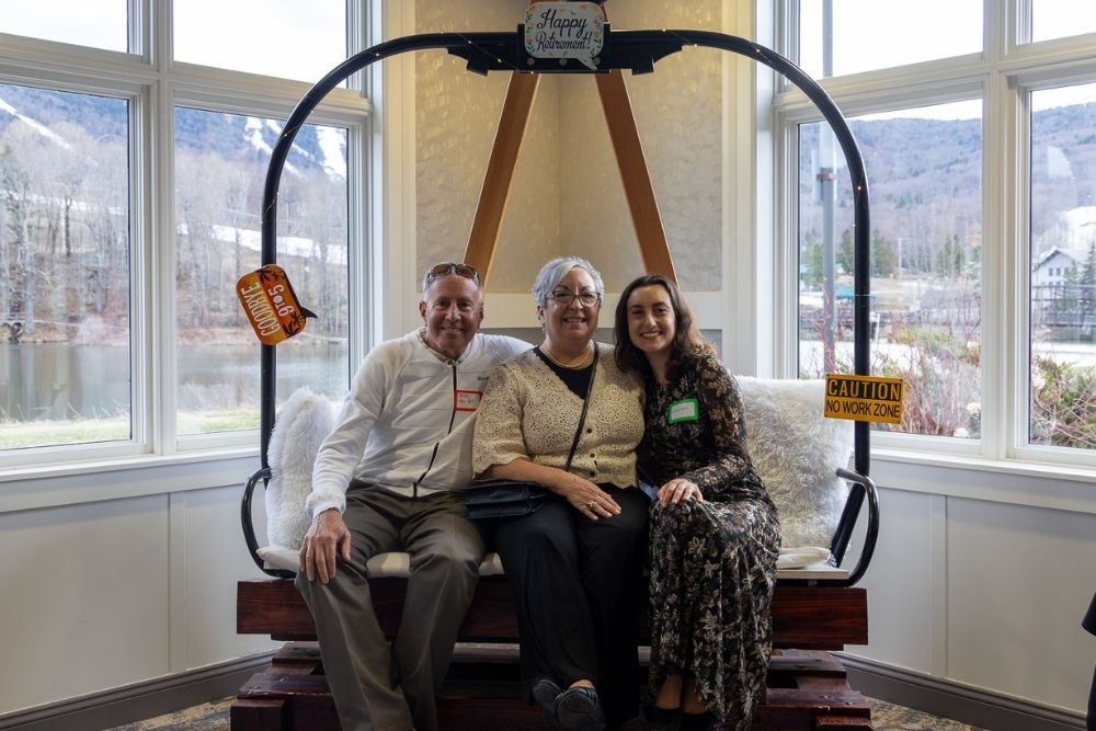 Sharon posing in a photo with her husband and daughter