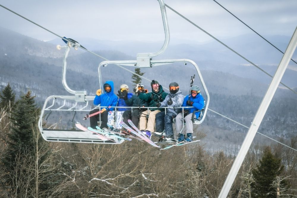 Skiers & riders waving to the camera on Superstar Six